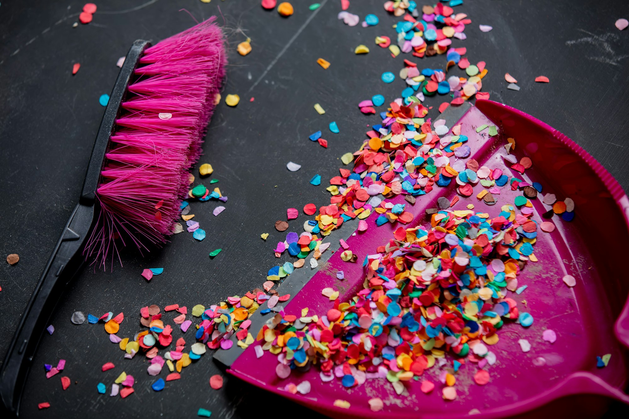 dustpan and broom for cleaning up confetti scattered on the floor after new Year's eve celebrations